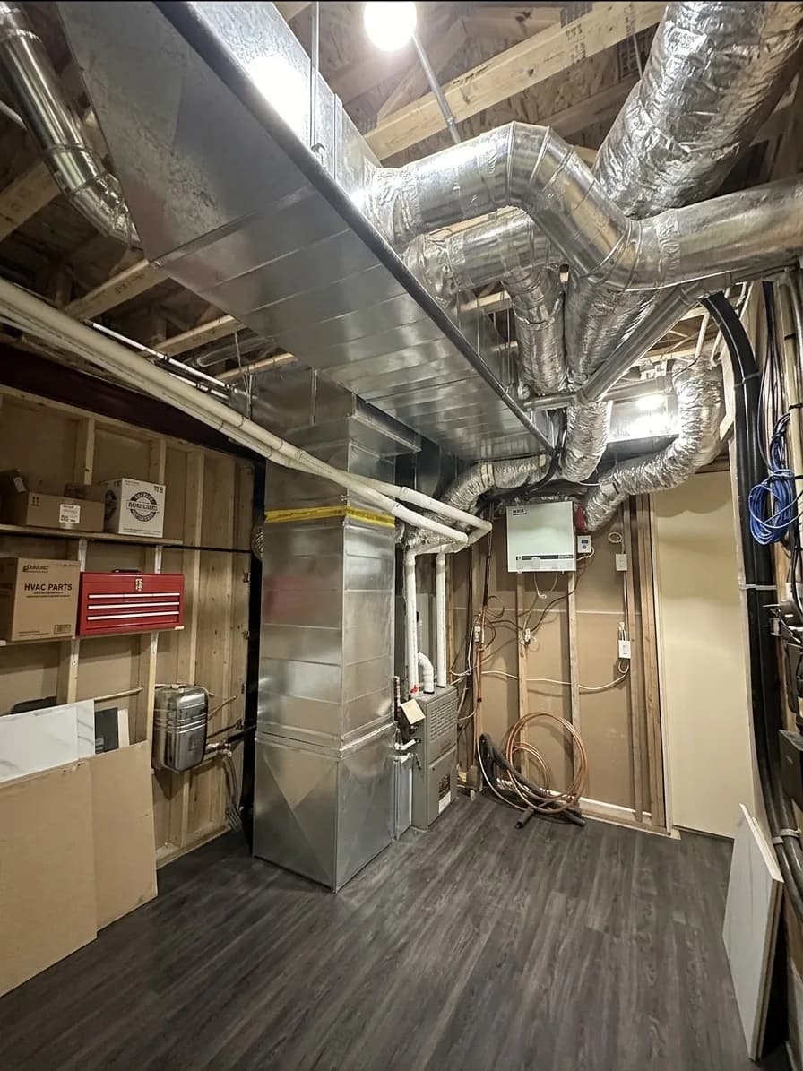 High-efficiency furnace installed in a finished basement with clean ductwork.